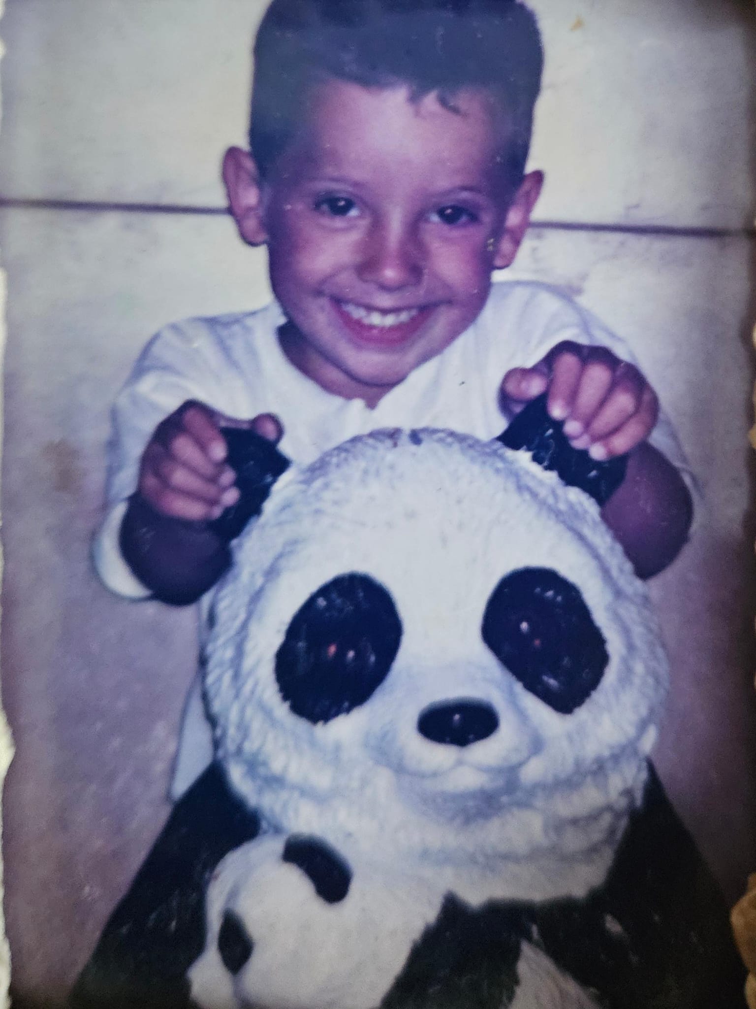 MK MAIK de niño sonriendo con un panda